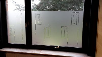 Fenêtre à deux vantaux vue de l'intérieur, film à effet sablé à motif de rectangles concentriques