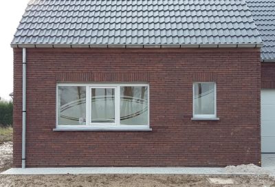 Fenêtre à trois vantaux d'une maison en briques rouges, film à effet sablé dessinant une grande ellipse