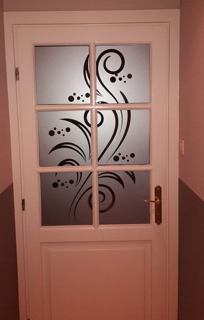 Porte intérieure blanche à six carreaux dont le vitrage porte un film à effet sablé ajouré de volutes et de bulles